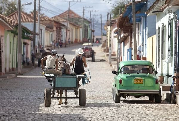 Horse and cart and vintage American car on cobbled street in the historic centre of Trinidad, UNESCO World Heritage Site, Cuba, West Indies, Central America