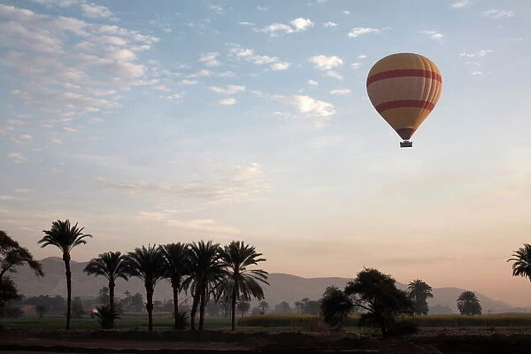 Hot air balloons carry tourists on early morning flights over the Valley of the Kings