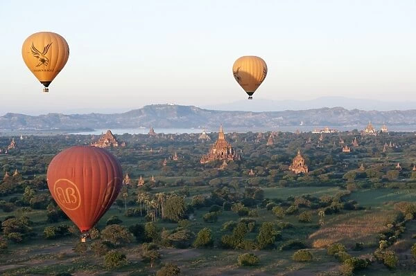 Hot air balloons flying over the terracotta temples of Bagan with the Irrawaddy river