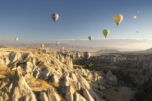 Hot air balloons over volcanic landscape in the dawn sky above Goreme, Cappadocia, Anatolia, Turkey, Asia Minor, Eurasia