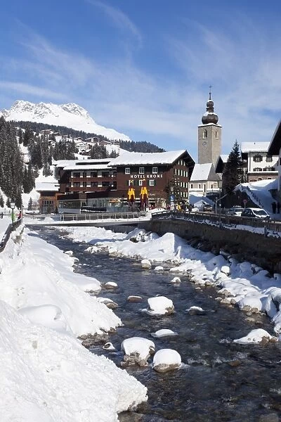 Hotel Krone, river and village church, Lech near St. Anton am Arlberg in winter snow