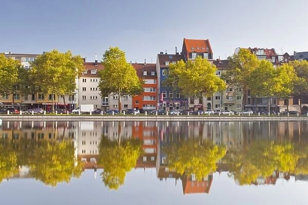 Houses and shops reflecting in a pond, Cologne, North Rhine-Westphalia, Germany, Europe
