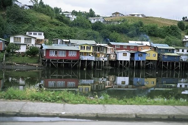 Houses on stilts reflected in the water, Palafitos, Castro, Chiloe Island