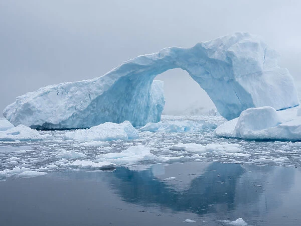 A huge arch formed in a tilted iceberg in Cierva Cove, Antarctica, Polar Regions