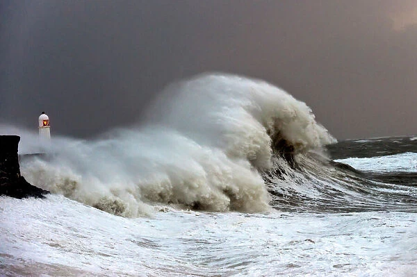 Huge waves crash against the harbour wall at Porthcawl, Bridgend, Wales, United Kingdom
