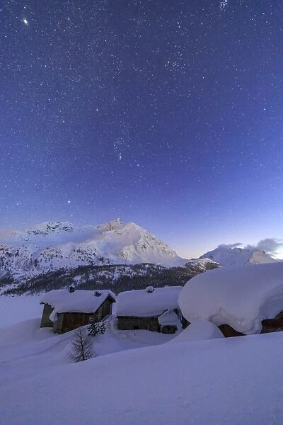 The huts of Spluga covered in thick snow during a clear starry night, Graubunden, Swiss Alps, Switzerland, Europe