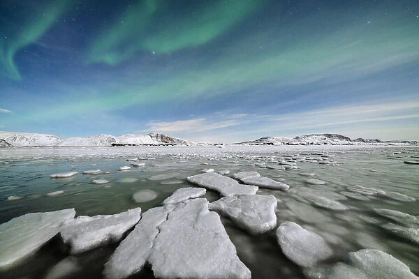 Ice blocks in the frozen Arctic sea lit by Northern Lights (Aurora Borealis)