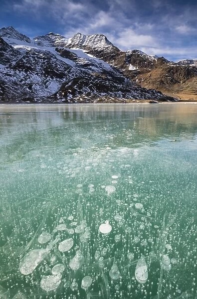 Ice bubbles in the turquoise water of the frozen White Lake (Lago Bianco), Bernina Pass