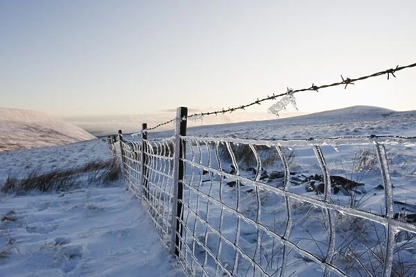 Ice covered fence on Pen y Fan mountain, Brecon Beacons National Park, Powys, Wales, United Kingdom