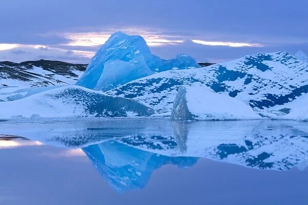 Icebergs covered in dusting of snow, winter, sunset, Jokulsarlon Glacial Lagoon, South Iceland