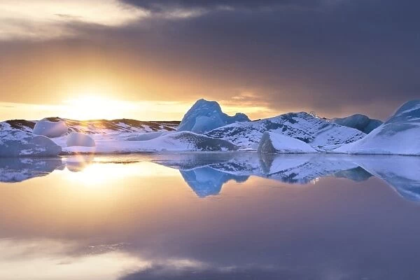 Icebergs covered in dusting of snow, winter, sunset, Jokulsarlon Glacial Lagoon, South Iceland