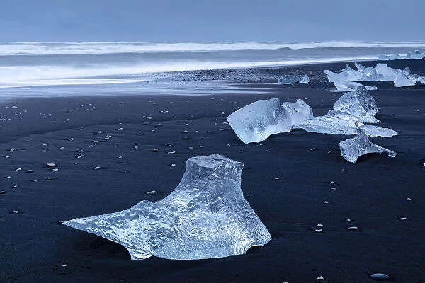 Icebergs from melting glacier on black sand beach near Jokulsarlon glacier lagoon, Vatnajokull National Park, Iceland