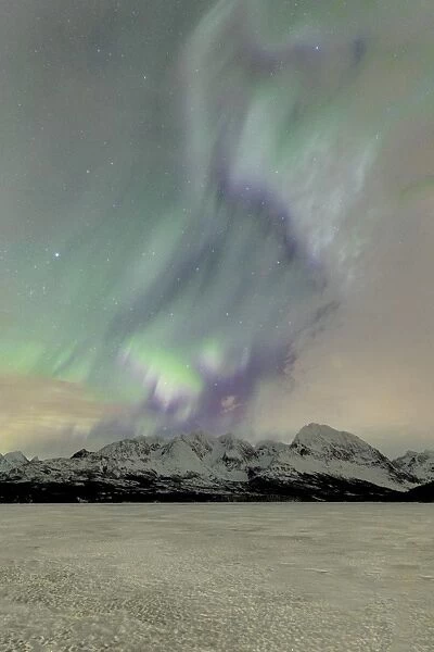 The icy lake of Jaegervatnet framed by the Northern Lights (aurora borealis)