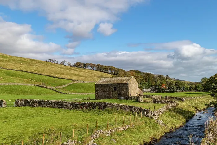 Framed Print : Idyllic countryside landscape with a stone barn, green fields, and a clear stream under a blue sky with fluffy clouds, North Yorkshire, England, United Kingdom, Europe