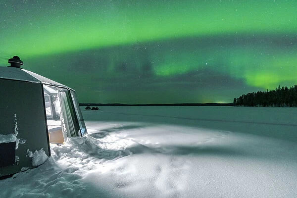 Illuminated empty igloo in the frozen landscape under Aurora Borealis (Northern Lights), Jokkmokk, Lapland, Sweden, Scandinavia, Europe