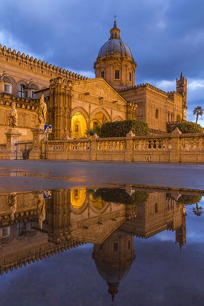 The illuminated Palermo Cathedral (UNESCO World Heritage Site) reflected in a puddle
