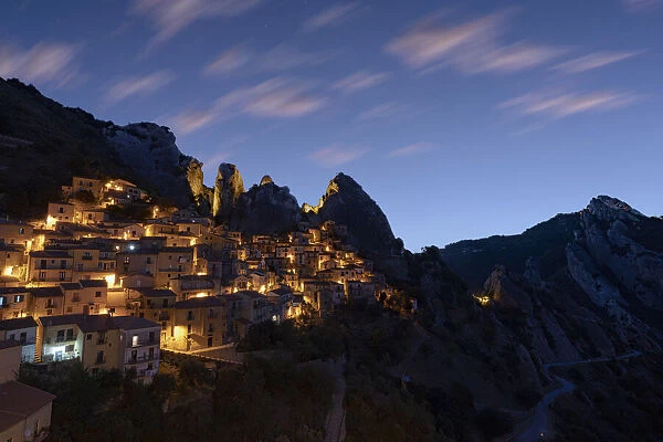 Illuminated village of Castelmezzano framed by Dolomiti Lucane peaks at sunrise