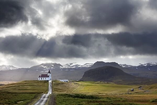 Ingjaldsholskirkja set against mountains on a dramatic stormy day, near Rif, Snaefellsnes Peninsula
