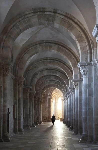 Interior north nave aisle with priest walking away, Vezelay Abbey, UNESCO World Heritage Site