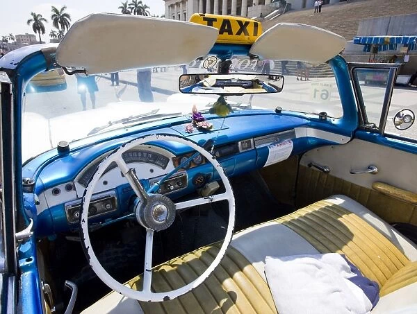 Interior of old American car being used as a taxi showing blue dashboard