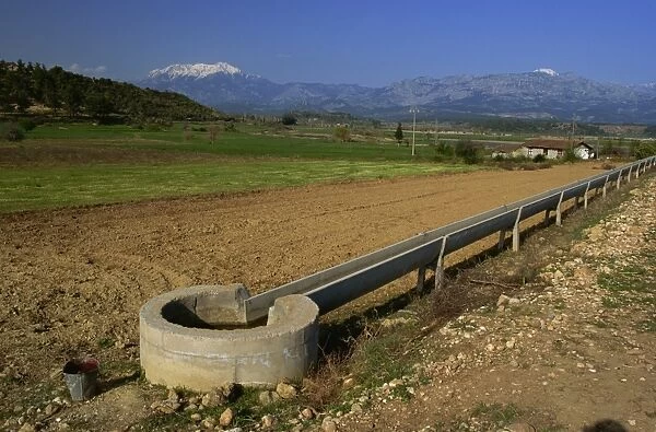 Irrigation channel in countryside near Kursunlu, with Kuyucak mountains in distance