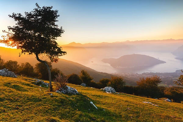 Iseo Lake and Monte Isola at sunset with fog in autumn season, Brescia Province, Lombardy
