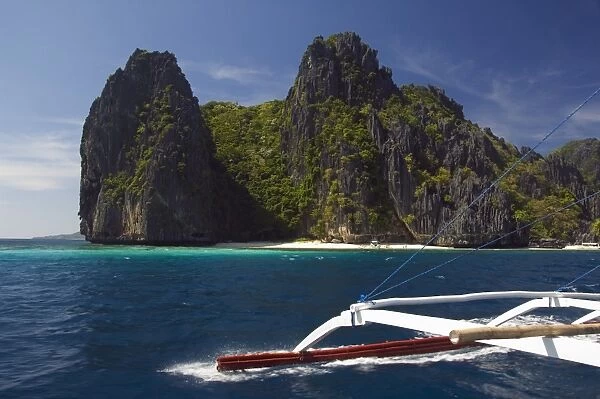 Island hopping by catamaran around coral fringe in clear waters