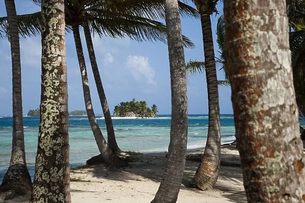 Islands in the San Blas archipelago in the Caribbean Sea, seen through palm trees on Dog Island