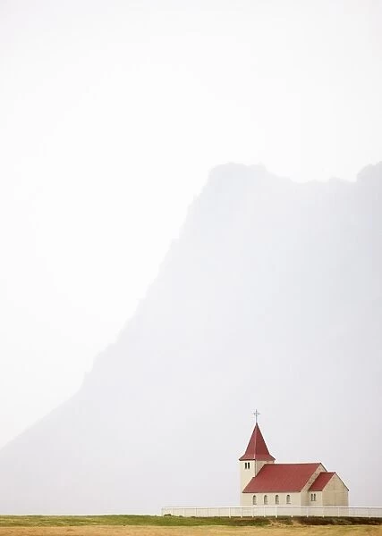 Isolated church with hazy outline of distant mountain in the background