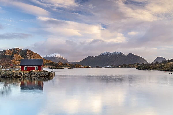 Isolated fishermans cabin reflected in the sea at dawn, Ballstad, Vestvagoy, Nordland county, Lofoten Islands, Norway, Scandinavia, Europe