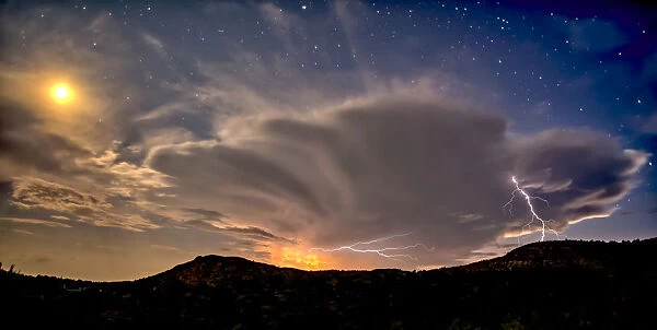 An isolated storm cell near Chino Valley being lit by the Moonlight during the summer