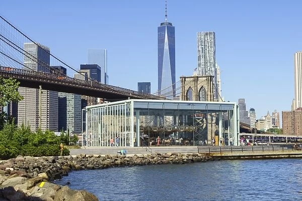 Janes Carousel in Brooklyn Bridge Park with Brooklyn Bridge and Lower Manhattan skyscrapers including One World Trade Center beyond, New York City, New York, United States of America, North America