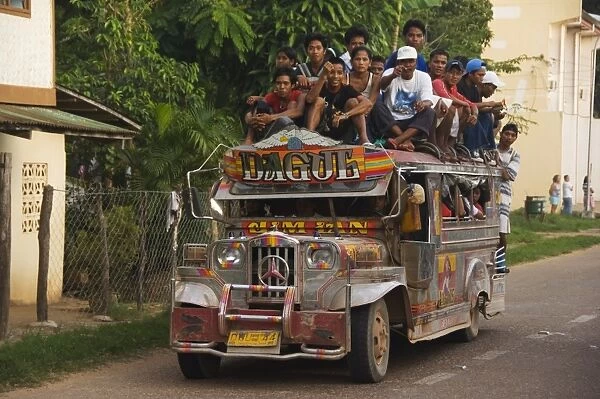 Jeepney truck with passengers crowded on roof