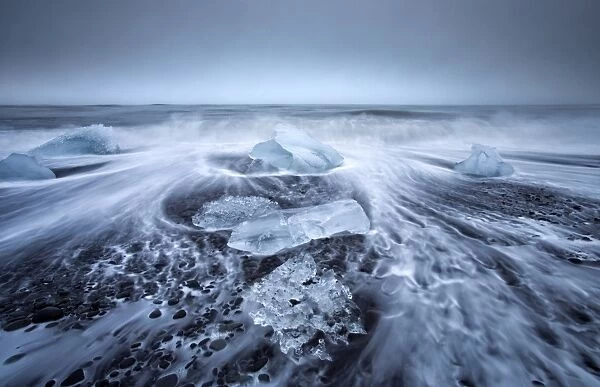 Jokulsa Beach on a stormy day, where icebergs from nearby Jokulsarlon glacial lagoon flow into the North Atlantic and are washed back onto the black volcanic sand beach, on the edge of the Vatnajokull National Park, South Iceland, Iceland, Polar Regions
