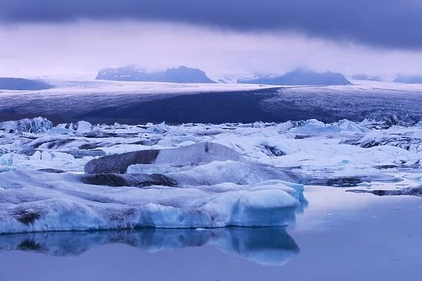 Jokulsarlon glacial lagoon beneath Breidarmerkurjokull (Vatnajokull) glacier which feeds it