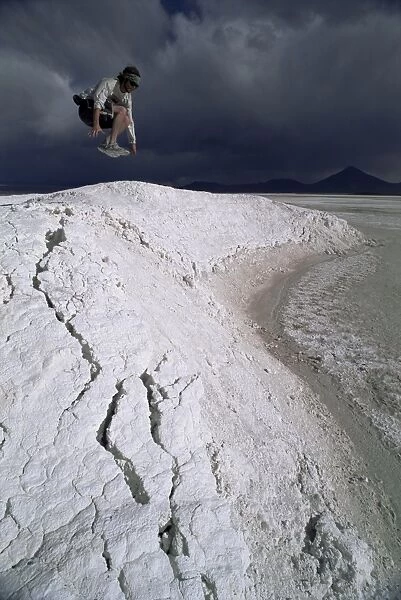 Jumping above the borax deposits on borders of Laguna Colorado, Bolivia, South America