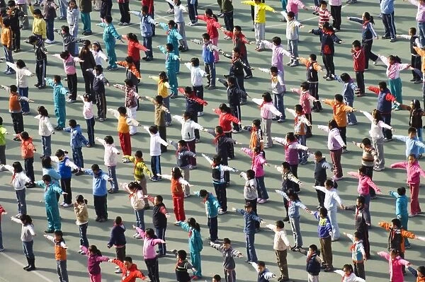 Junior school children exercising in colourful clothes, Beijing, China, Asia