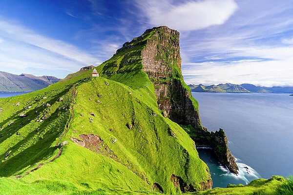 Kallur lighthouse on cliffs covered with grass with Borgarin mountain peak on background, Kalsoy island, Faroe Islands, Denmark, Europe