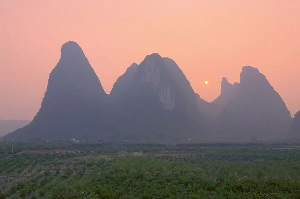 Karst landscape and setting sun, Yangshuo, Guangxi Province, China, Asia