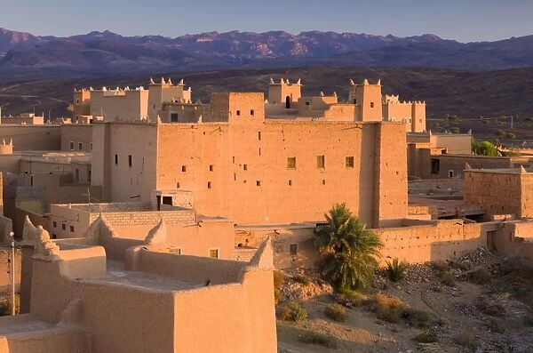 Kasbah bathed in evening light with the Jbel Sarhro Mountains in the distance