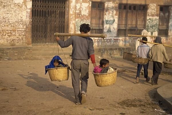 Kids taxi, two children carried in baskets on a pole