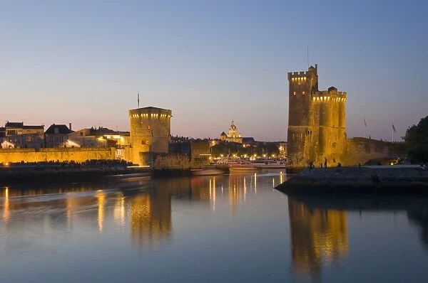 La Chaine and St. Nicholas towers at the entrance to the ancient port of La Rochelle at dusk