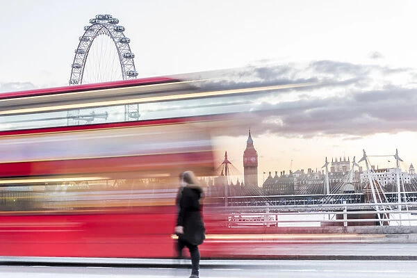 A lady crossing Waterloo Bridge with a bus passing between her, the London Eye and Big Ben