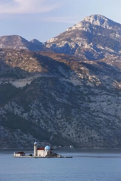 Our Lady of the Rocks island with mountains behind, on fjord near Perast
