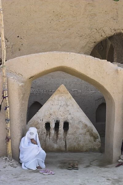 Lady visiting a possible early 8th Century tomb of a 19th century AD saint behind mosque for blesssing for childbirth  /  sickness, No-Gonbad Mosque also known as Khoja Piada or Masjid-e Haji Piyada, Balkh, Balkh province, Afghanistan, Iraq