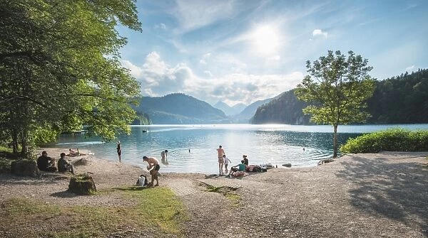 Lake Alpsee near Castle Neuschwanstein and Fuessen town with people enjoying leisure activities, Bavaria, Germany, Europe