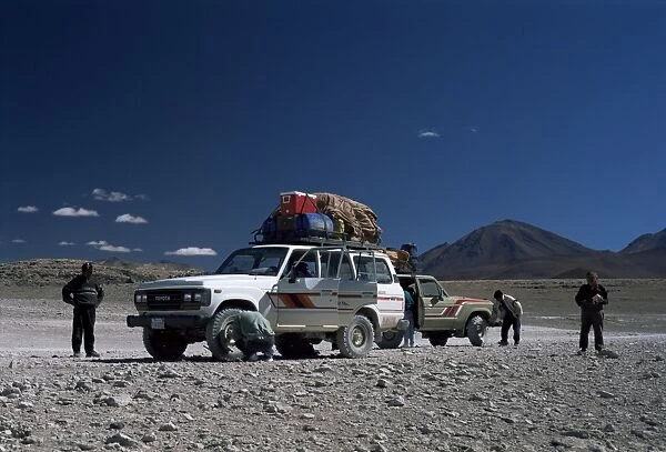 Landcruisers and tourists on jeep tour taking a break on Uyuni salt flat