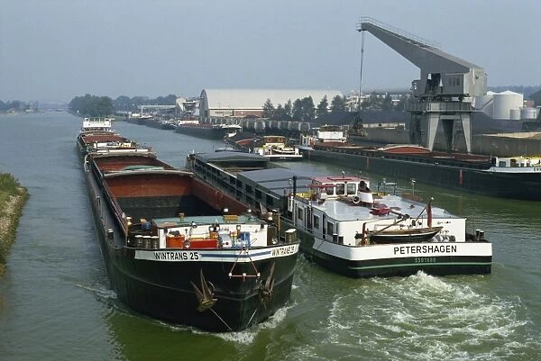 Large barges pass on busy canal near the Netherlands border