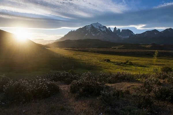 Late sunrays breaking through the clouds before the towers of the Torres del Paine National Park, Patagonia, Chile, South America
