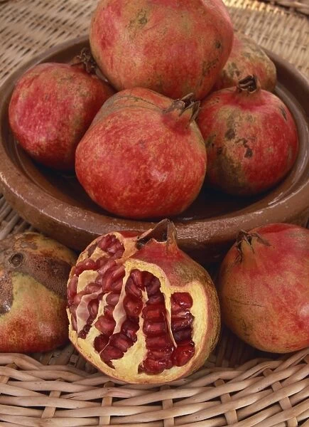 Still life of a bowl of red pomegranates